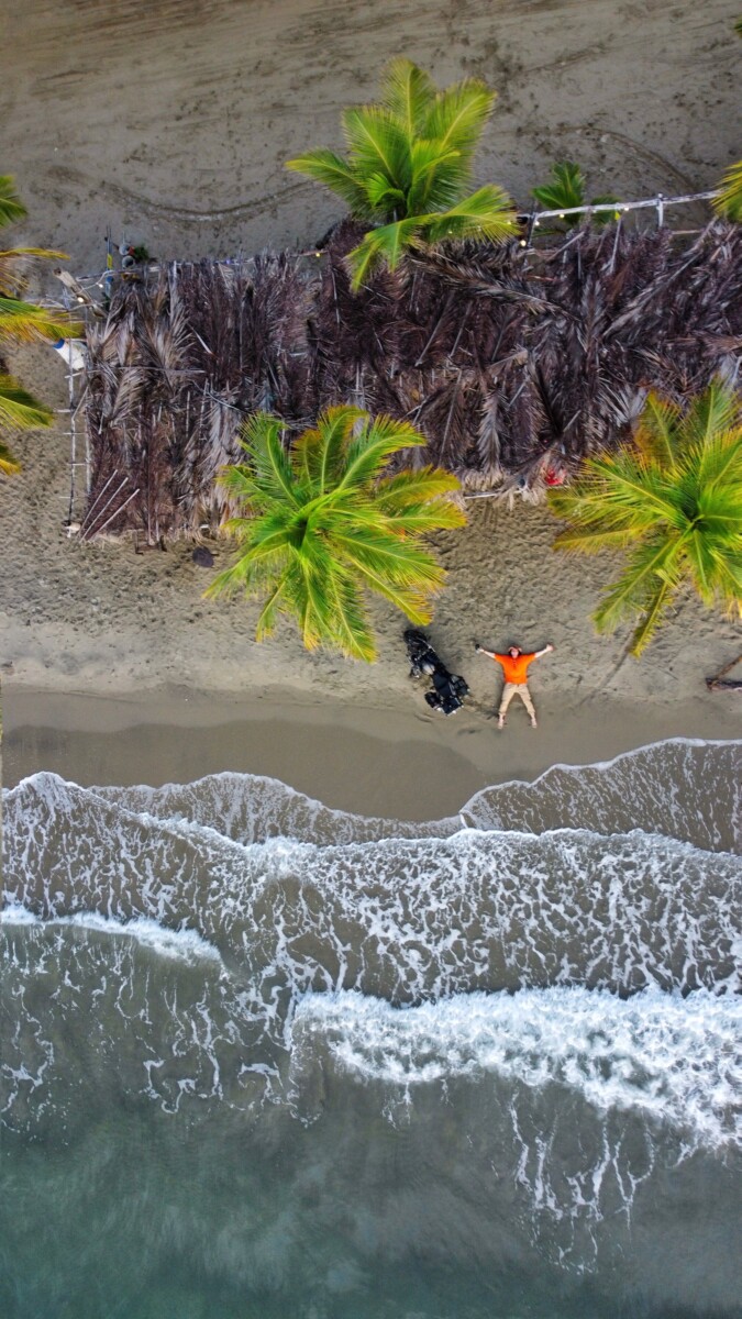 Vista aérea de una persona en la playa de Coveñas entre palmeras