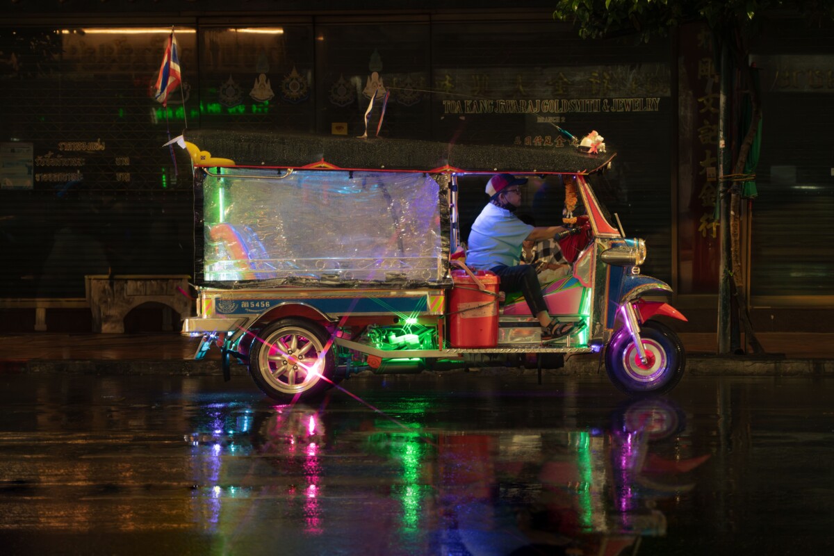 Tuk-tuk de colores en una calle de Bangkok de noche