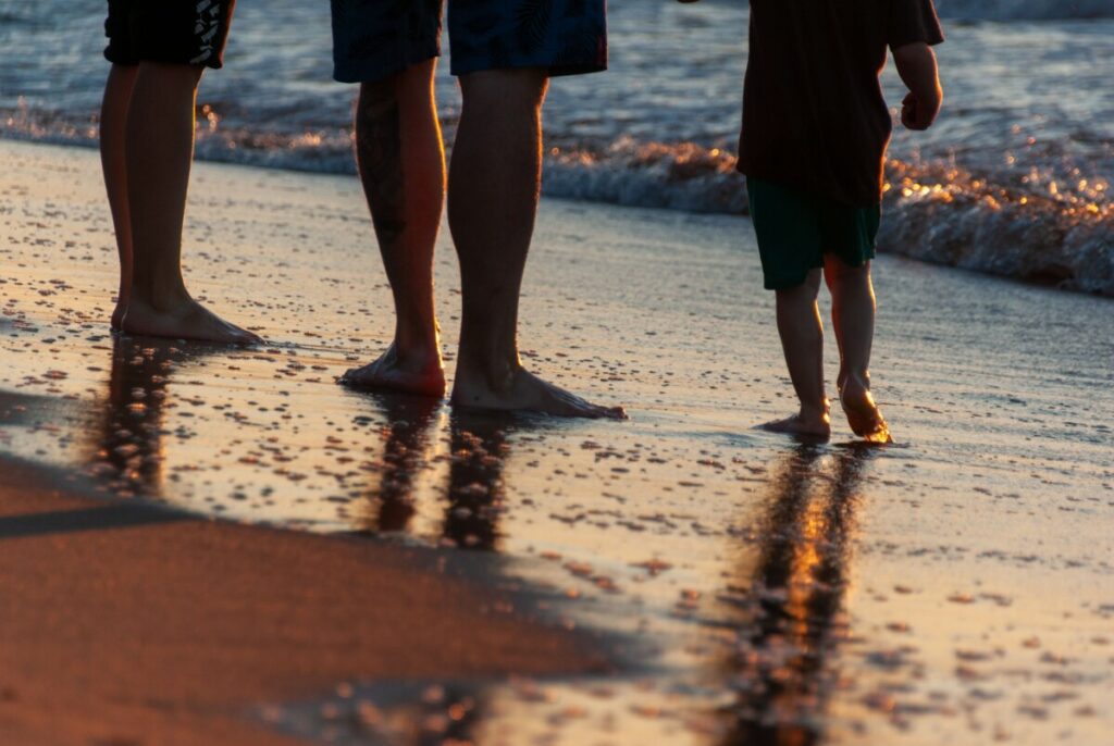 Familia caminando por la playa al atardecer